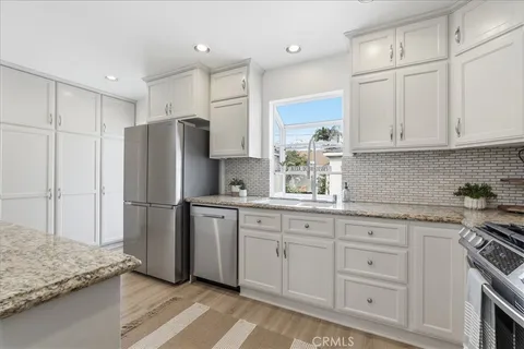 a kitchen with white cabinets and stainless steel appliances