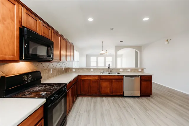 a kitchen with stainless steel appliances granite countertop a stove a sink and a microwave