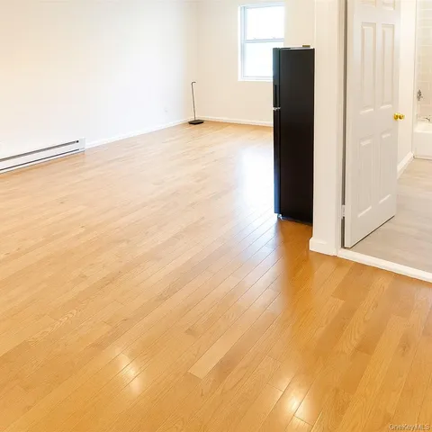 an empty room with wooden floor and a window
