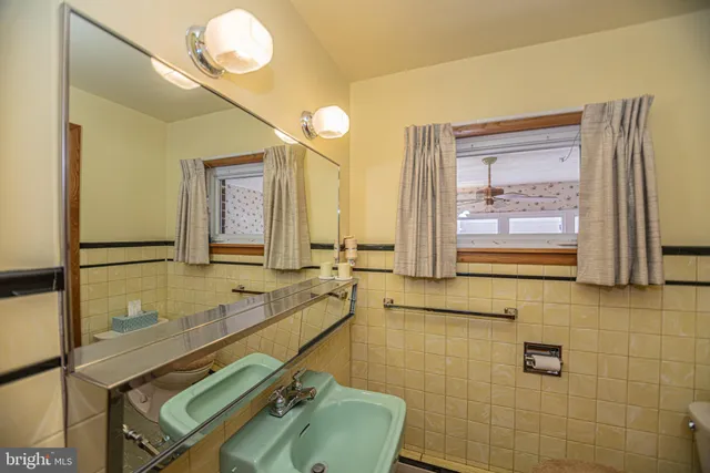 a bathroom with a granite countertop sink a toilet and mirror