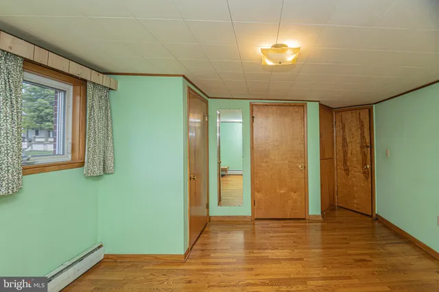 a view of a room with wooden floor and cabinets