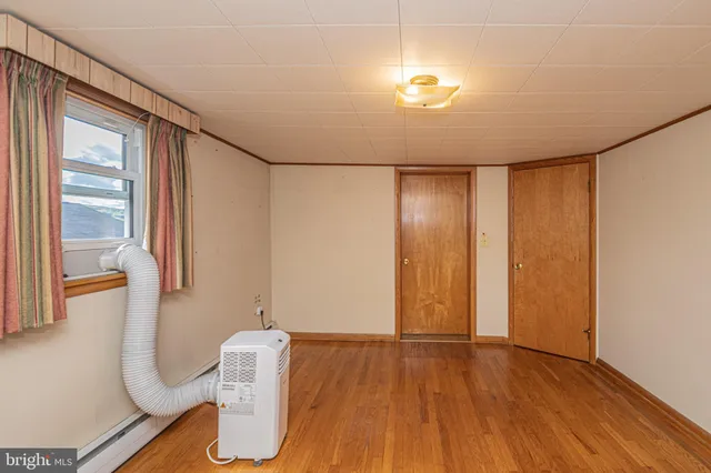 a view of a room with wooden floor and window