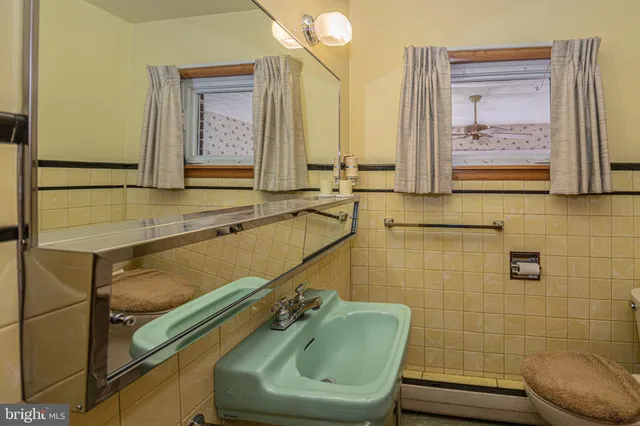 a bathroom with a sink mirror and toilet