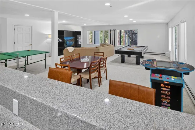 a living room with pool table flat screen tv and windows