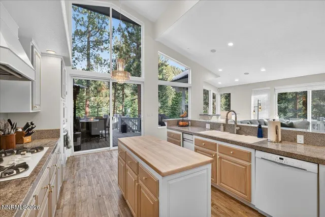a kitchen with stainless steel appliances kitchen island granite countertop a stove a sink and a refrigerator