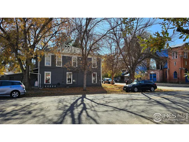 a view of a black white house with a yard covered in snow