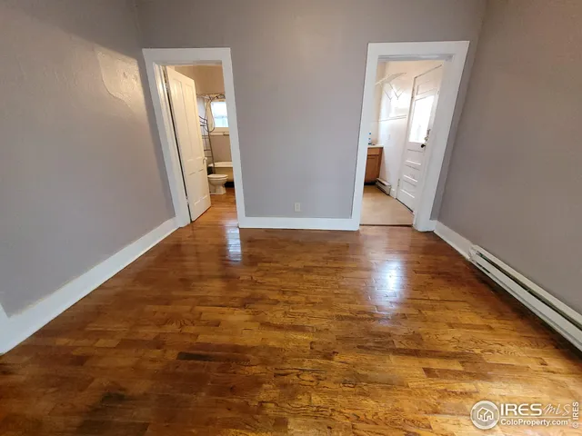 a view of an empty room with wooden floor