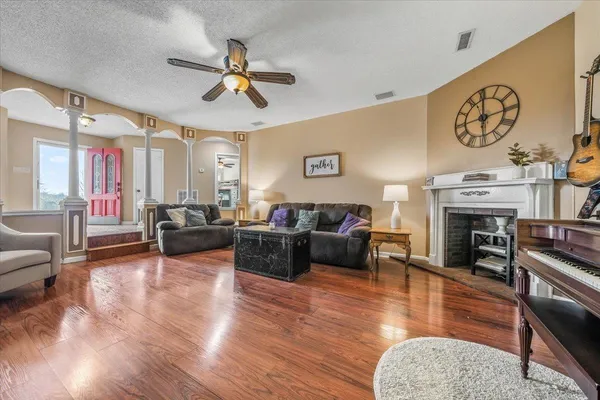 a living room with furniture a fireplace and wooden floor