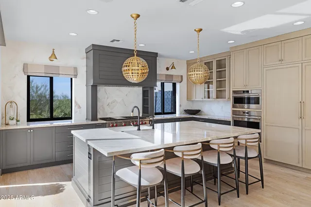 a kitchen with kitchen island granite countertop a sink a stove and cabinets