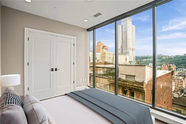 a bedroom with a large window and a bed
