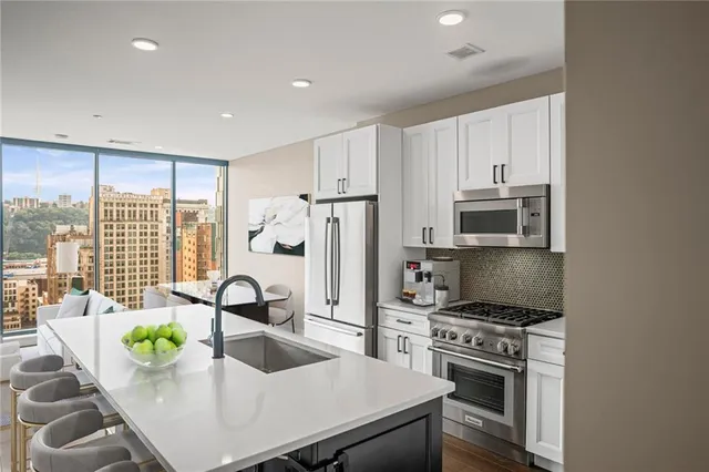 a kitchen with kitchen island a stove a sink and a refrigerator