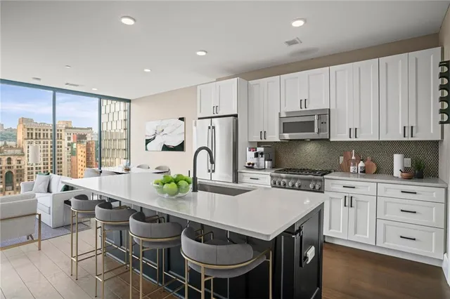 a kitchen with granite countertop a table chairs stove and refrigerator