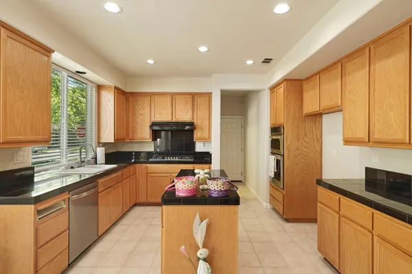 a large kitchen with stainless steel appliances lots of counter space and a sink