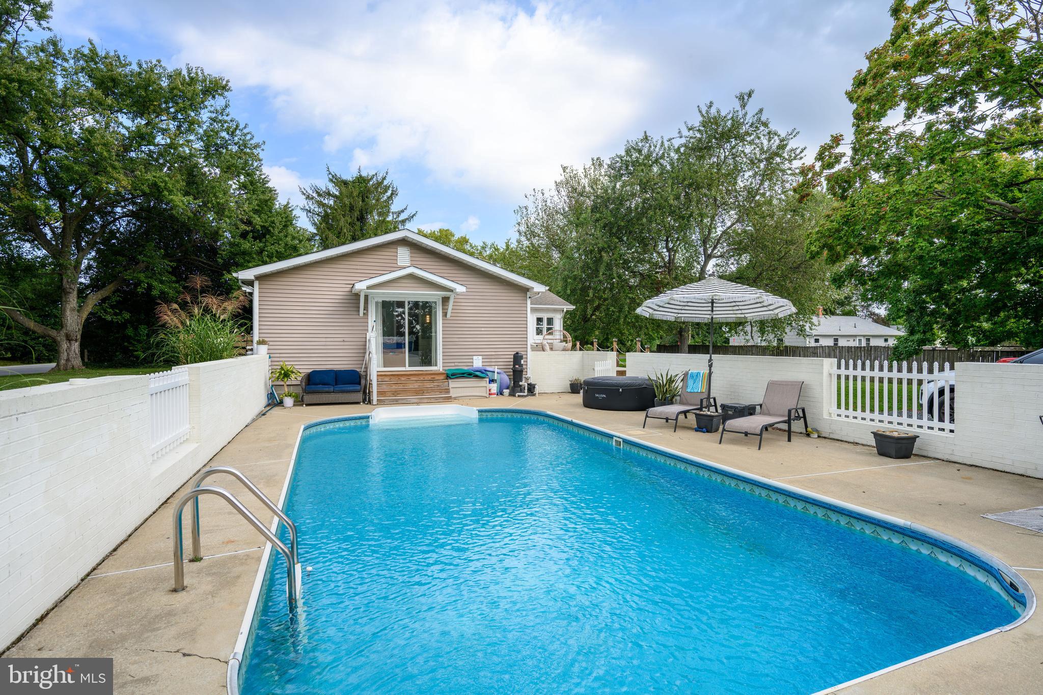 7653 Broad Neck Road Chestertown, MD 21620 - Photo 11 of 39 a view of a house with pool and chairs under an umbrella