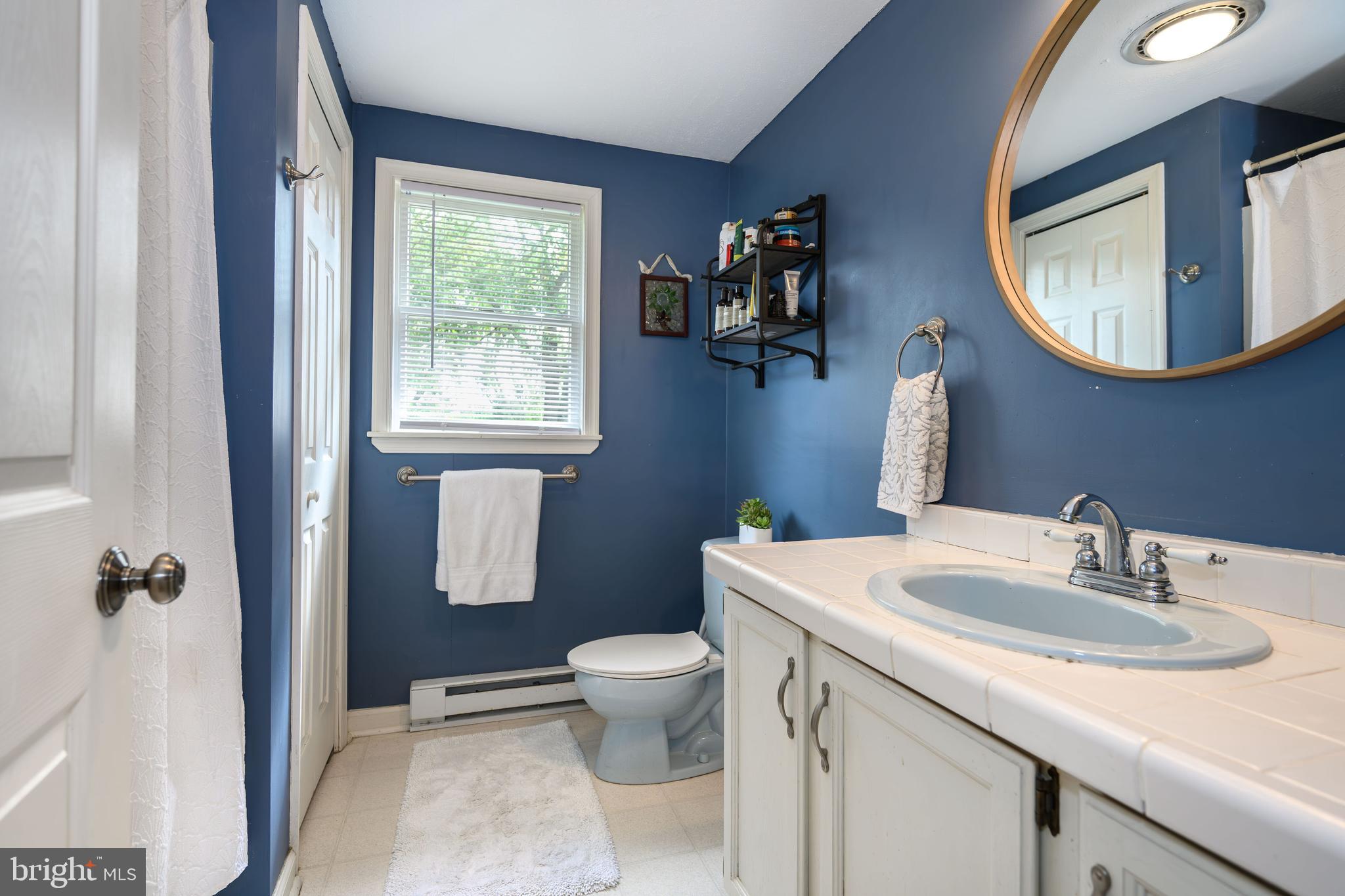 7653 Broad Neck Road Chestertown, MD 21620 - Photo 33 of 39 a bathroom with a granite countertop sink toilet a mirror and a window