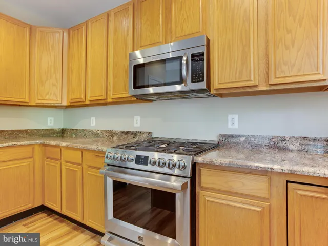 a kitchen with stainless steel appliances granite countertop a sink and a window