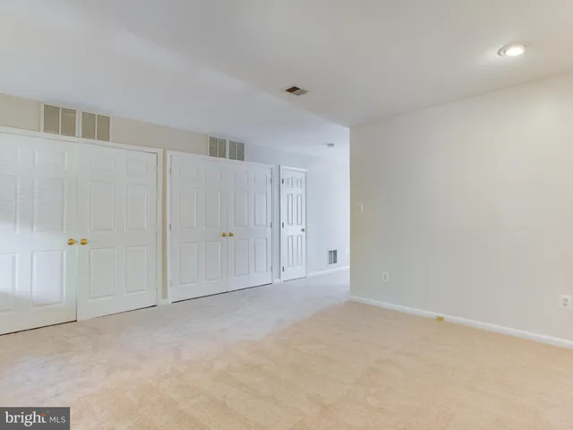 a view of an empty room with a chandelier fan