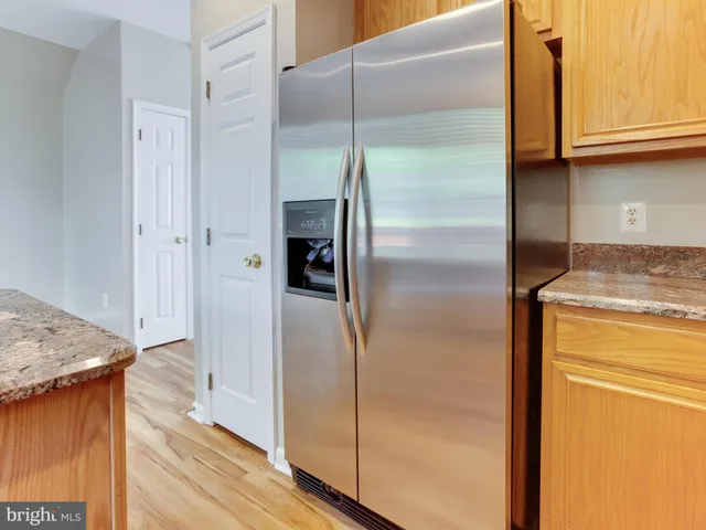 a kitchen with stainless steel appliances granite countertop a refrigerator and a stove top oven