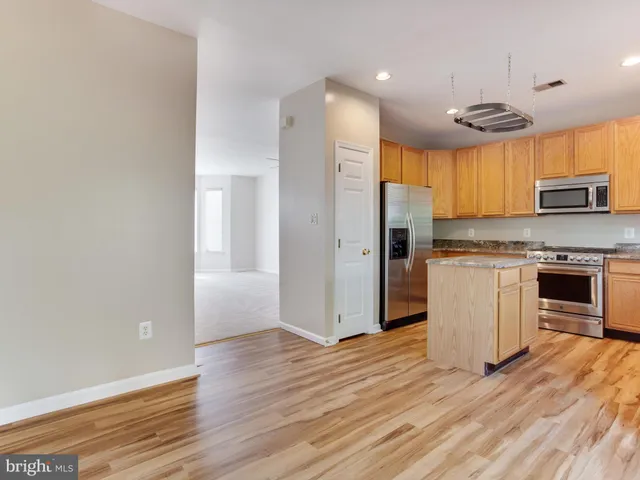 a kitchen with stainless steel appliances granite countertop a sink a refrigerator and a stove