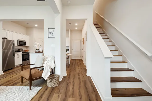 a view of a living room with furniture and wooden floor