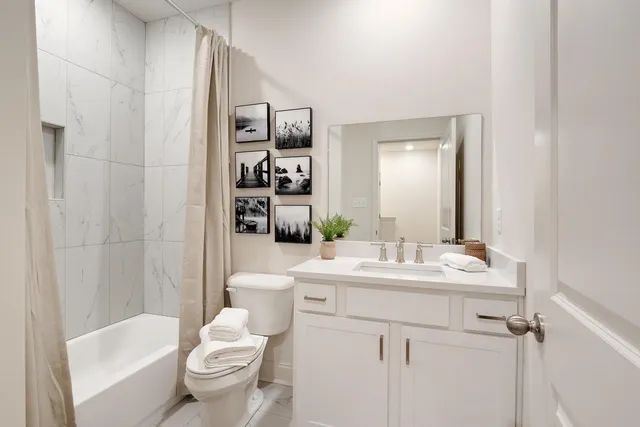 a bathroom with a sink toilet vanity and shower