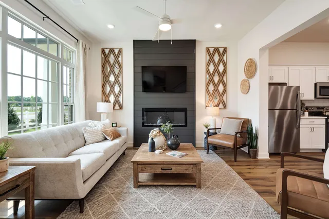 a living room with furniture fireplace and a large window