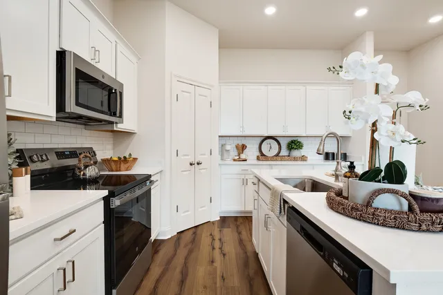 a kitchen with granite countertop a sink a stove and cabinets