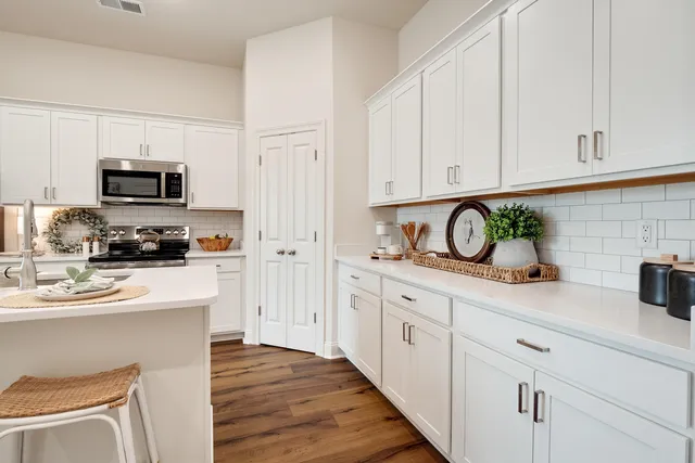 a kitchen with white cabinets and appliances