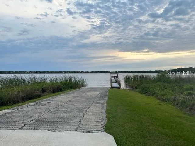 a view of a pathway both side of grassy field with shrub