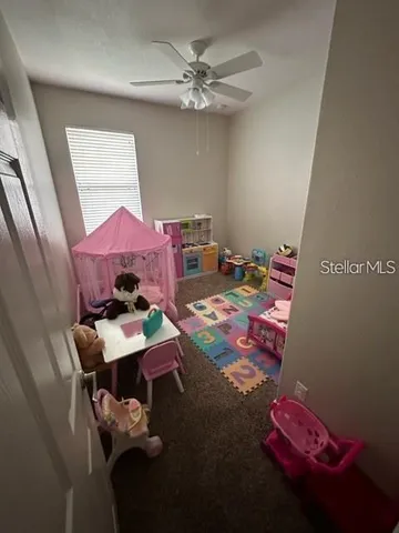 a room with furniture and a chandelier fan
