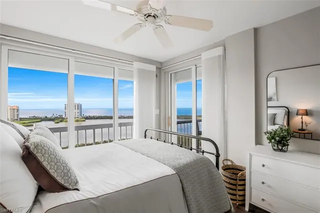 a bedroom with a bed table and a large mirror
