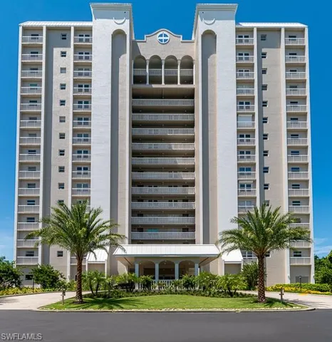 a front view of a building with a yard and plants