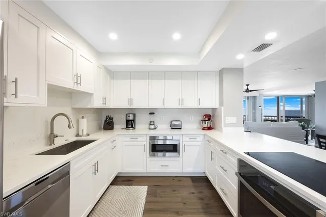 a kitchen with kitchen island white cabinets and white appliances