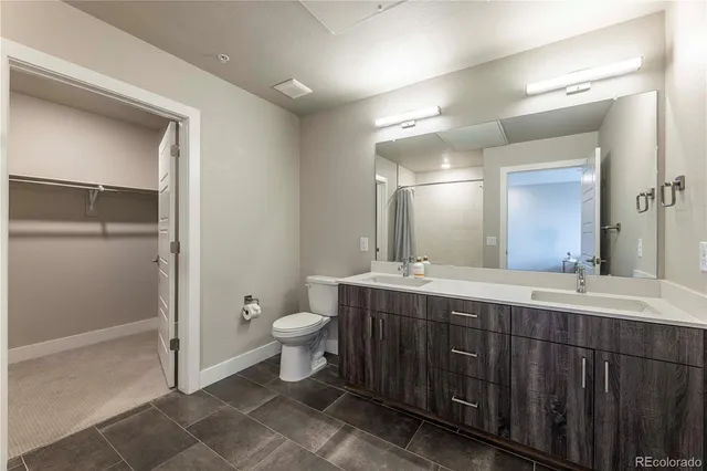 a spacious bathroom with a double vanity sink mirror and toilet