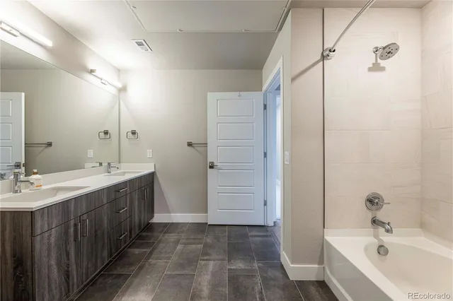 a bathroom with a double vanity sink and mirror with shower