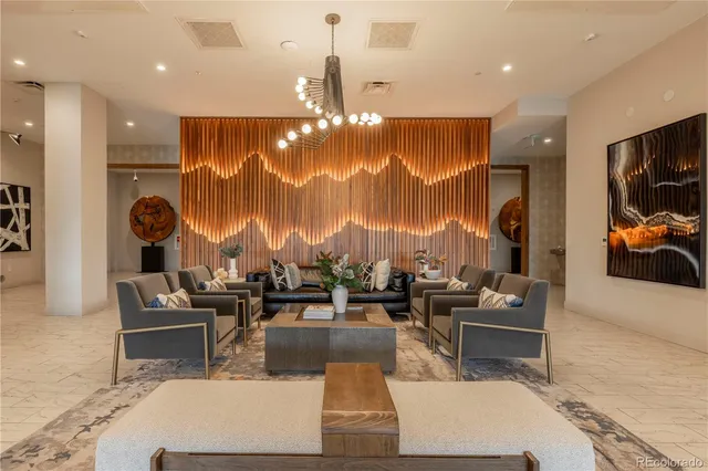 a living room with couches a coffee table and chandelier