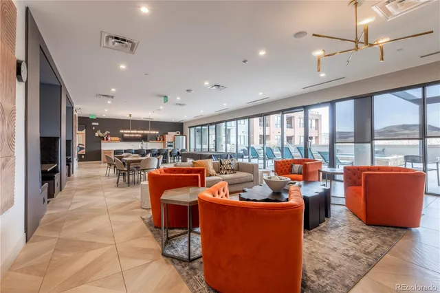 a living room with furniture a large window and a chandelier
