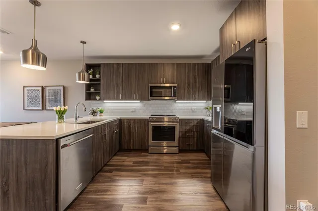 a kitchen with stainless steel appliances granite countertop a refrigerator and a stove top oven