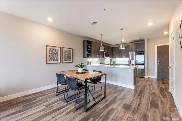 a living room with stainless steel appliances kitchen island a table and chairs
