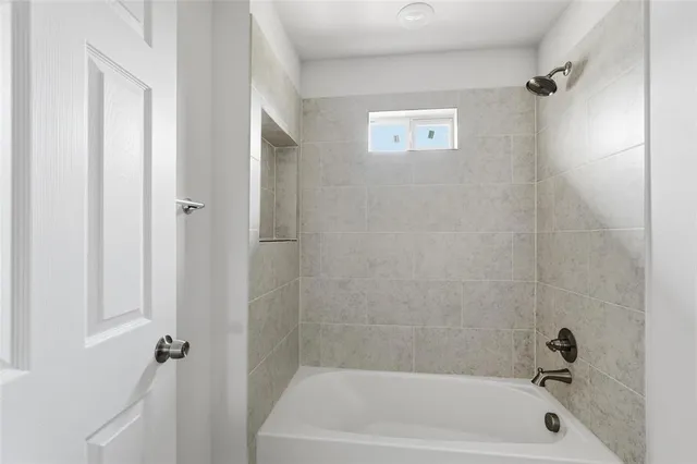 an empty room with wooden floor chandelier fan and windows