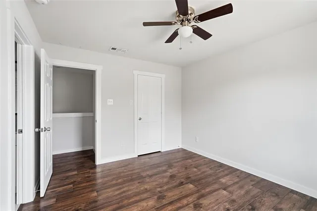 a view of a big room with wooden floor and windows