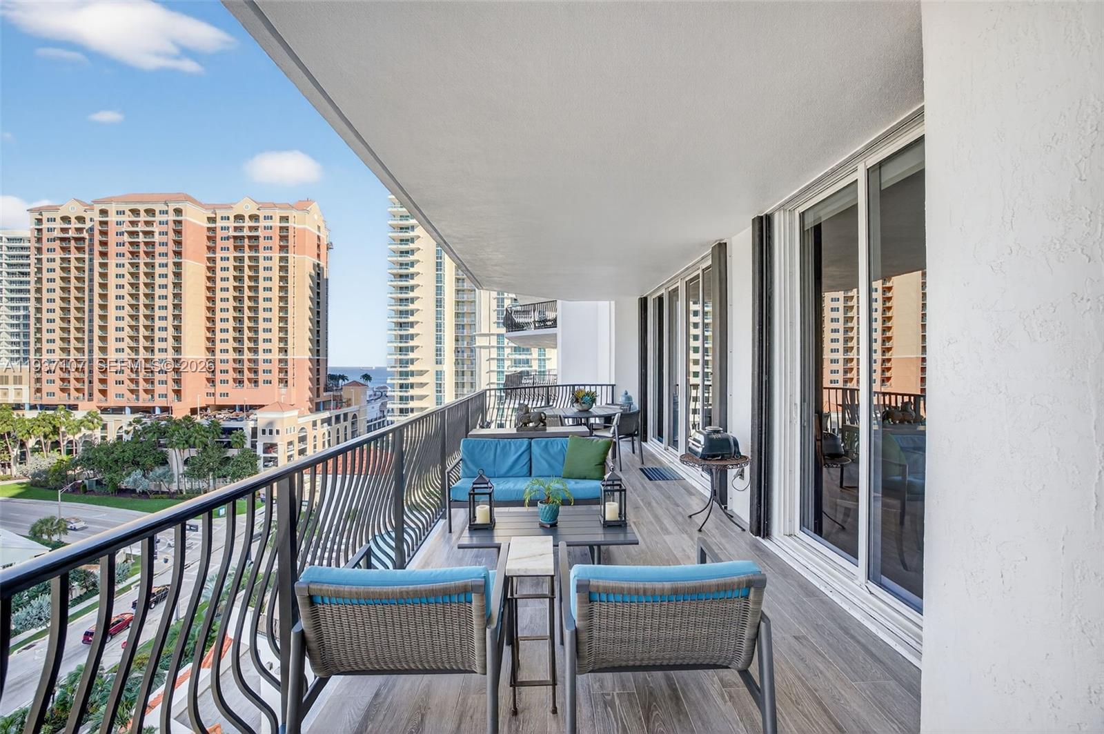 100 South Birch Road, Unit 1103F Fort Lauderdale, FL 33316 - Photo 22 of 80 Long Balcony w/ new plank tile flooring. 3 sets of slides lead to balcony, from Family Rm, Guest Rm & Primary Bedroom
