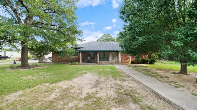 a front view of a house with a yard and trees