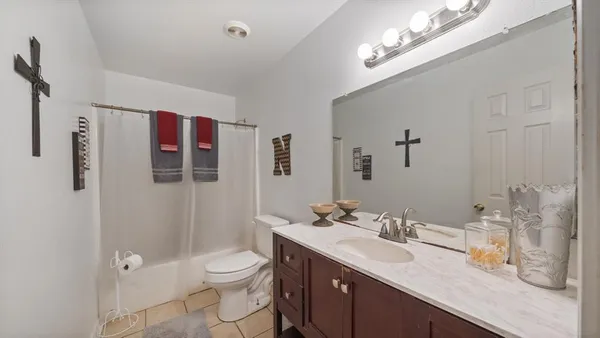 a bathroom with a granite countertop sink a toilet and shower