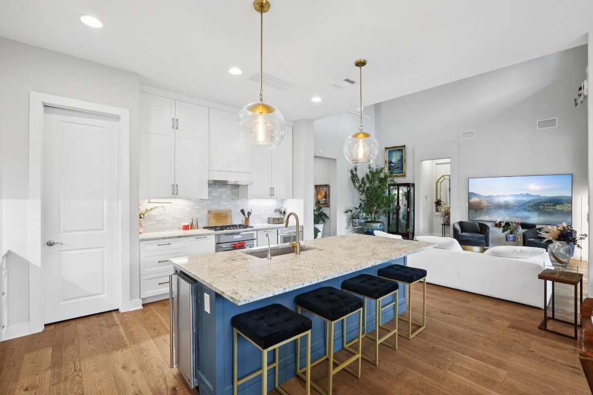 101 Cascading Water Place Austin, TX 78734 - Photo 11 of 36 a kitchen with kitchen island a dining table chairs and a wooden floor