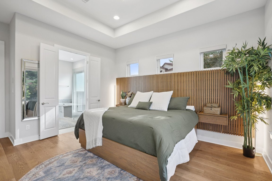 101 Cascading Water Place Austin, TX 78734 - Photo 17 of 36 a bedroom with a large bed and a potted plant