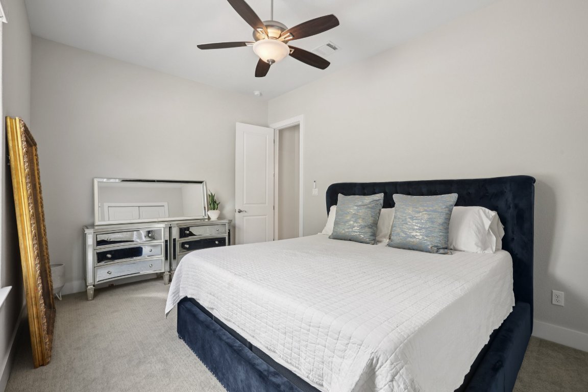 101 Cascading Water Place Austin, TX 78734 - Photo 25 of 36 a bedroom with a bed and a chandelier