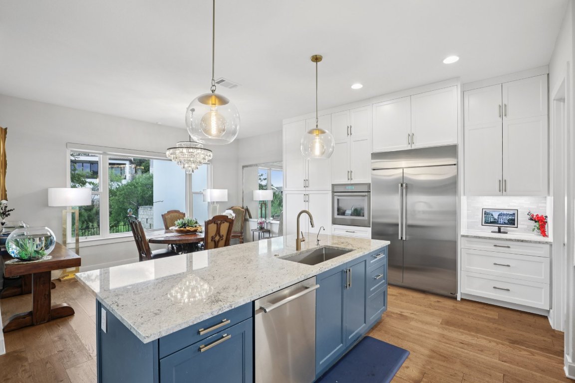 101 Cascading Water Place Austin, TX 78734 - Photo 8 of 36 a kitchen with stainless steel appliances granite countertop a sink a refrigerator and a view of living room