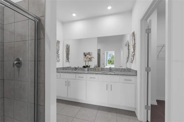 a bathroom with a granite countertop sink a mirror and a shower