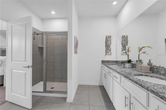 a bathroom with a granite countertop sink a shower and a mirror